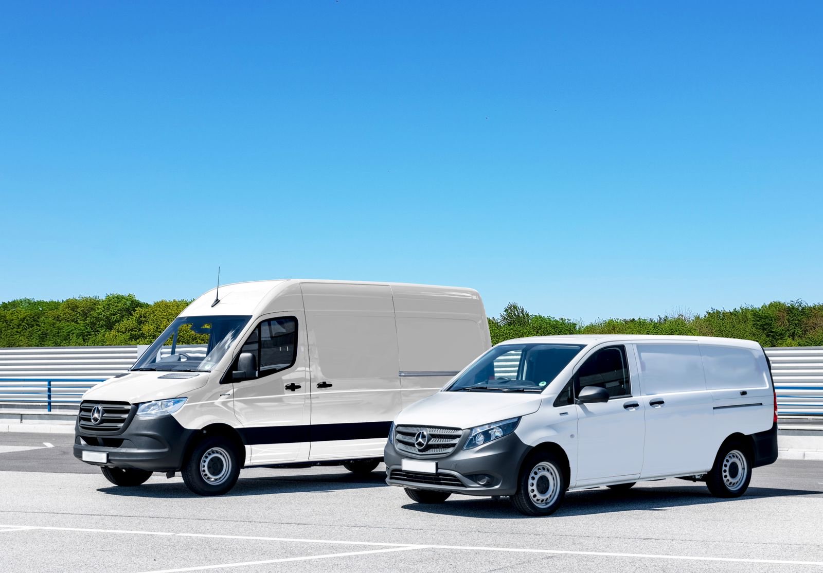 Weiße Transporter einer Firmenflotte, nebeneinander auf einem Betriebshof geparkt.